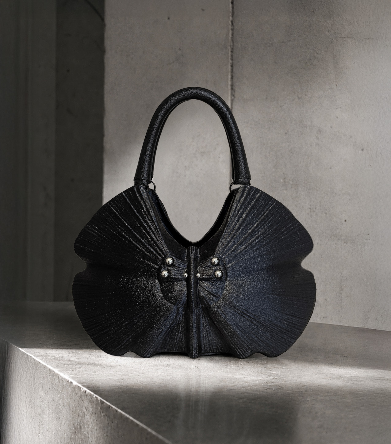 RAN: sculptural black handbag on a marble plinth