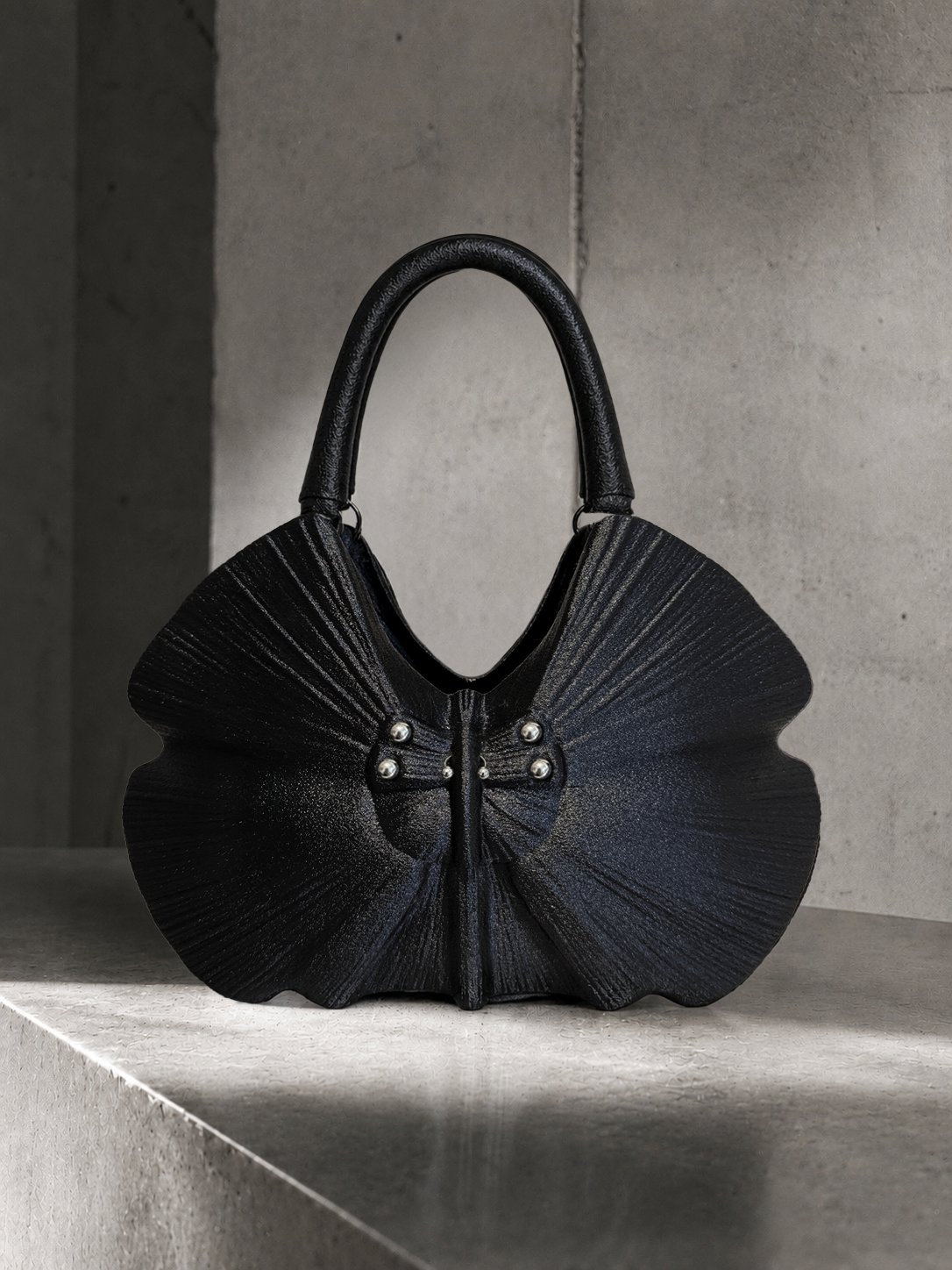 RAN handbag, front view on a marble plinth